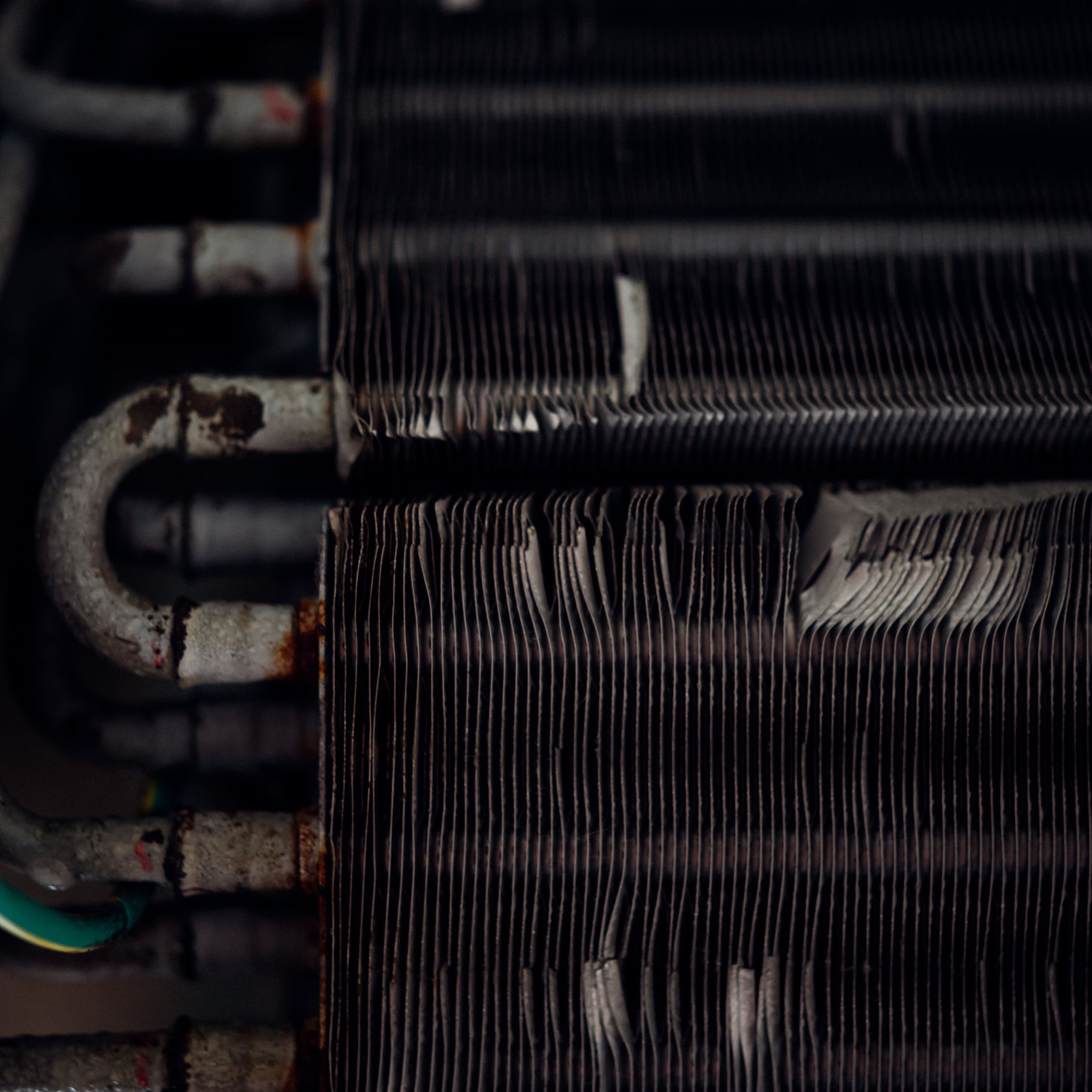 A close up view of air conditioner coils in need of a cleaning. 